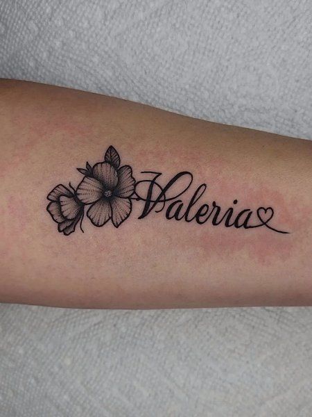 a woman's arm with flowers and the word valeria written in cursive writing