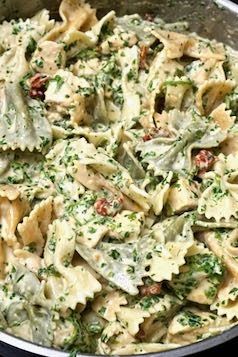 a pasta dish with broccoli and tomatoes in a saucepan on the stove