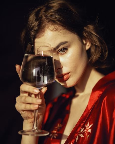 a woman holding a glass of wine in her hand