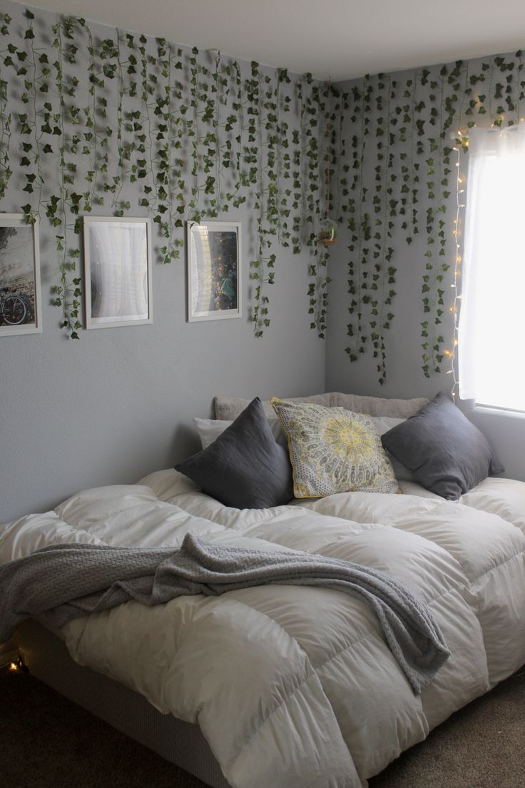 a bed sitting in a bedroom next to a window with ivy on the wall behind it