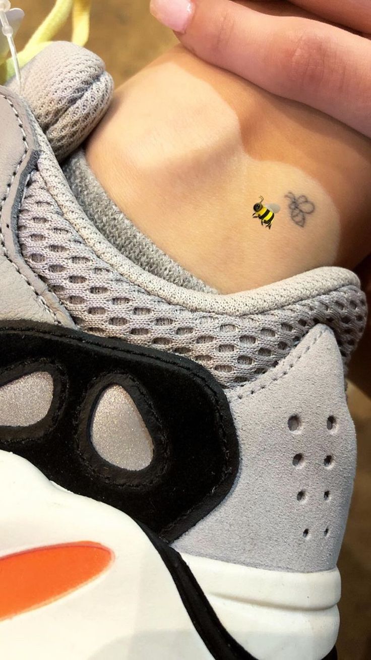 a woman's foot with a small tattoo on her left ankle and the bottom part of her shoe