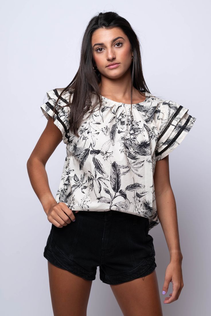 Add a touch of elegance to your wardrobe with our Midnight Meadows Toile Top. Featuring a classic toile design in timeless black and white, and finished with charming ruffle sleeves, this blouse is perfect for any occasion. fill 100% Cotton Import Fit Guide: Libby is 5ft 9 inches; Bust 34”, Waist 25”, Hips 34” Model is wearing a small True to size *available at our bandit location Elegant Ruffle Sleeve Floral Print Blouse, Elegant Ruffle Sleeve Blouse With Floral Print, Elegant Blouse With Floral Print And Ruffle Sleeves, Elegant Cotton Floral Print Blouse, Elegant Ruffle Sleeve Cotton Blouse, Elegant Cotton Blouse With Floral Print, Elegant Cotton Blouse With Ruffle Sleeves, Elegant Cotton Blouse With Flutter Sleeves, Black Butterfly Sleeve Blouse For Spring