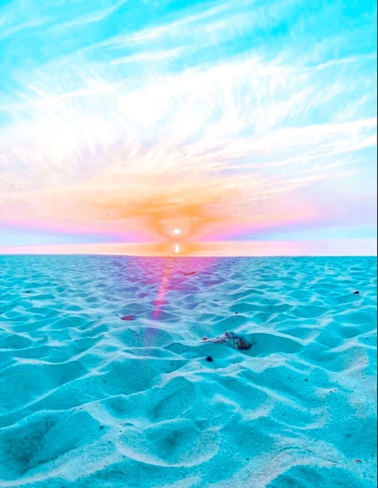 the sun is setting over an ocean with sand and blue sky in the foreground