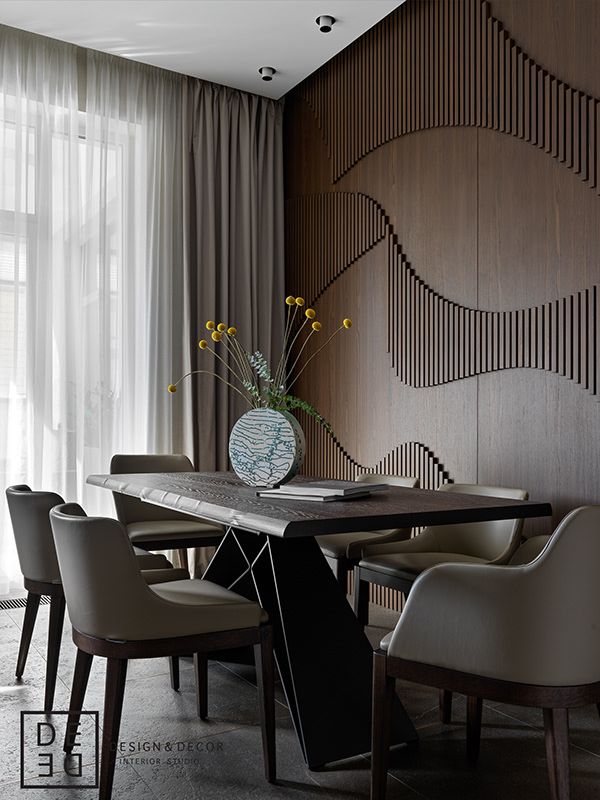 a dining room table with chairs and a vase filled with flowers on top of it