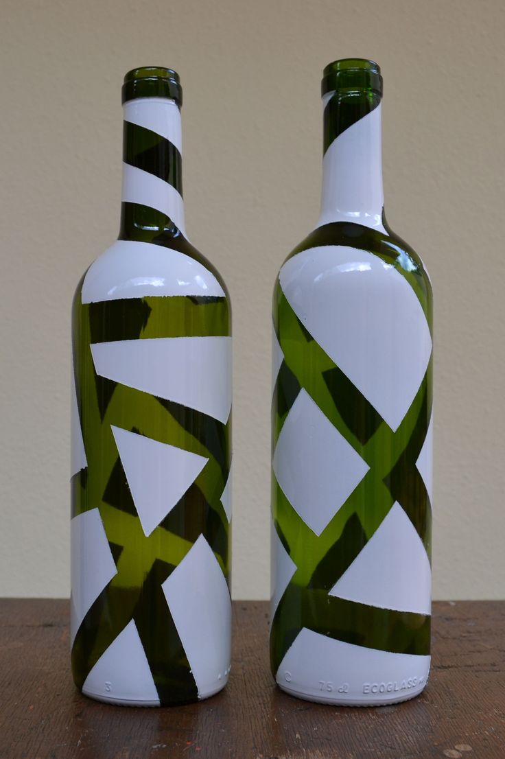 two green and white vases sitting on top of a wooden table