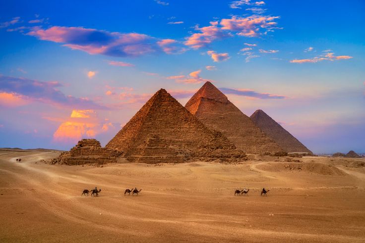 three pyramids in the desert with camels and people riding on them at sunset