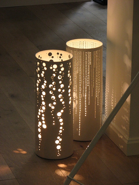 two white lamps sitting on top of a wooden floor