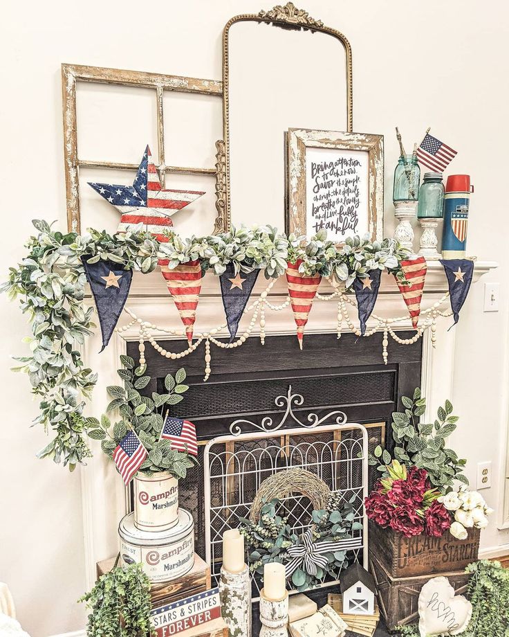 a fireplace decorated for the fourth of july with american flags and greenery on it