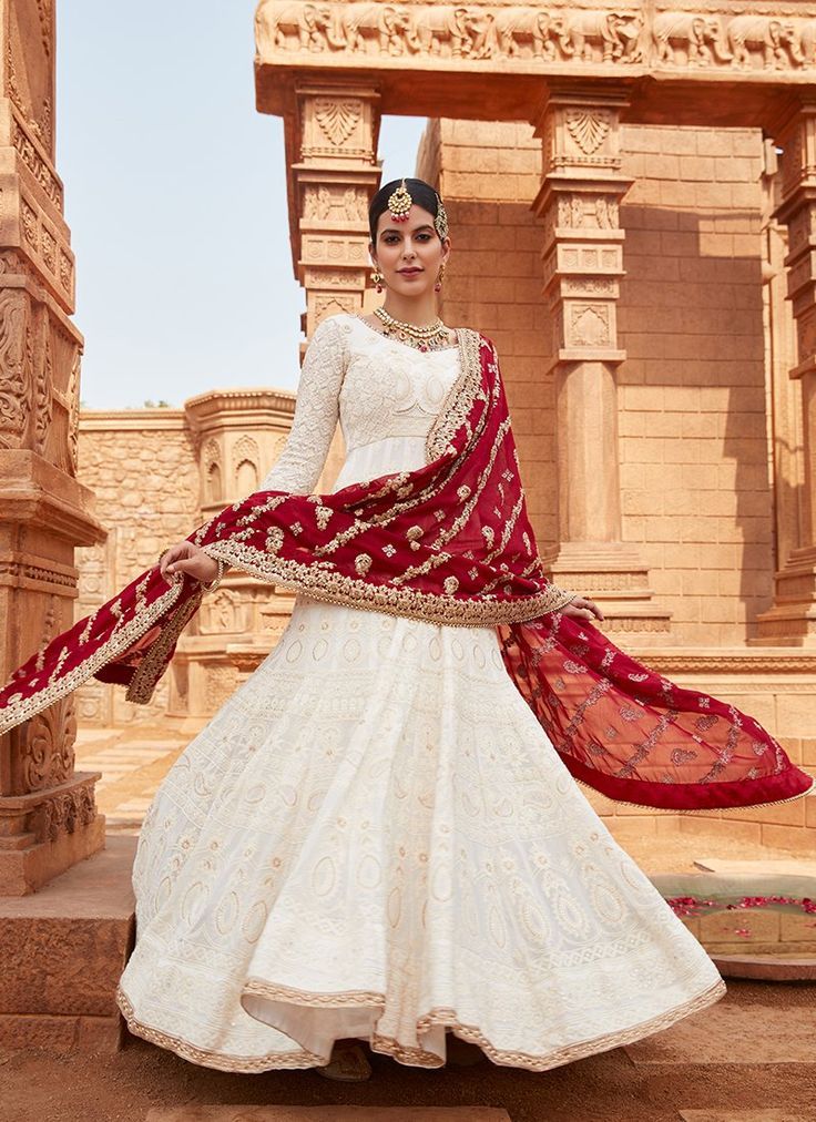 a woman wearing a white and red lehenga