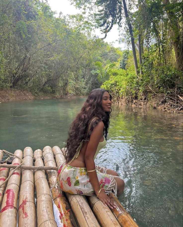 a woman sitting on top of bamboo raft in the water