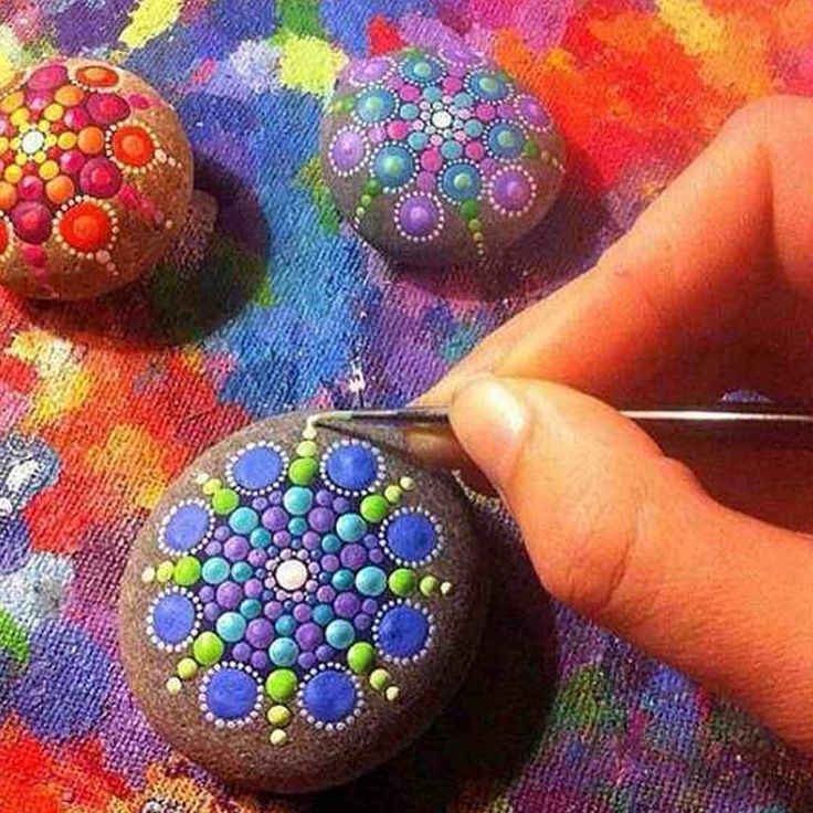 someone is painting rocks with colorful designs on them