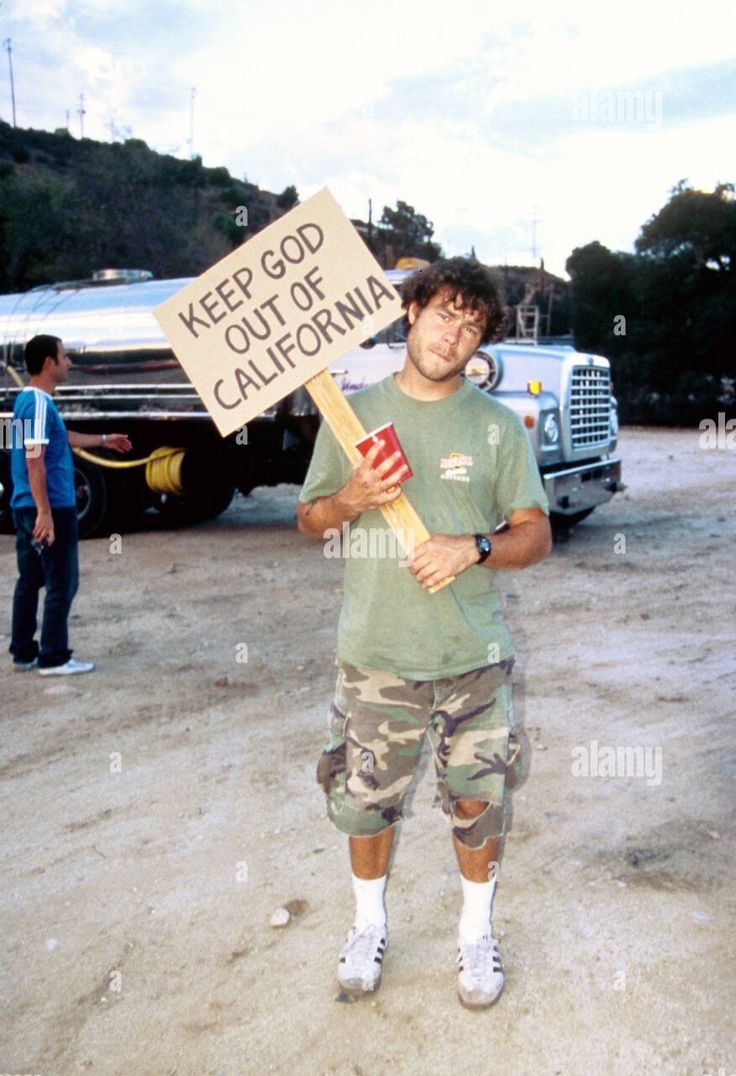 a man holding a sign that says keep god out of california