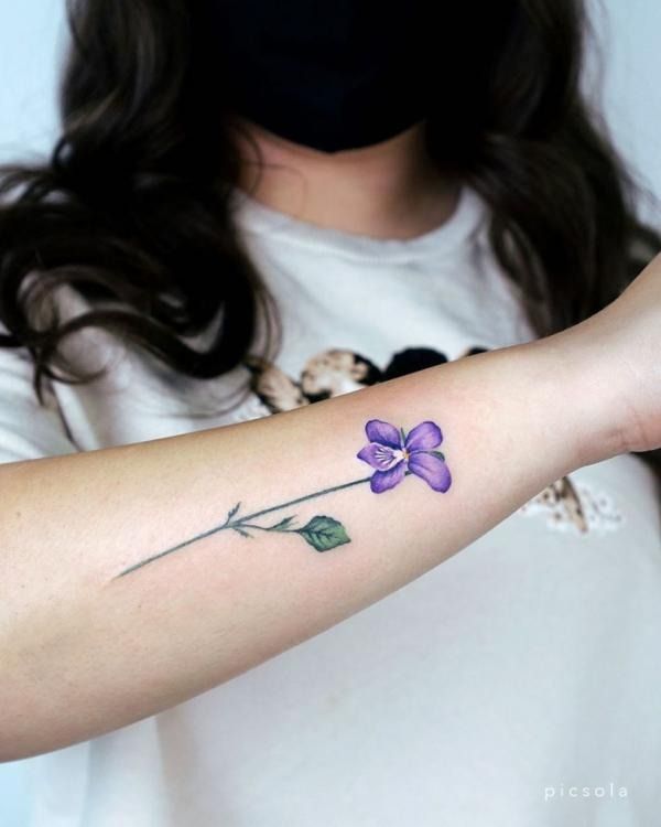 a woman with a purple flower tattoo on her arm