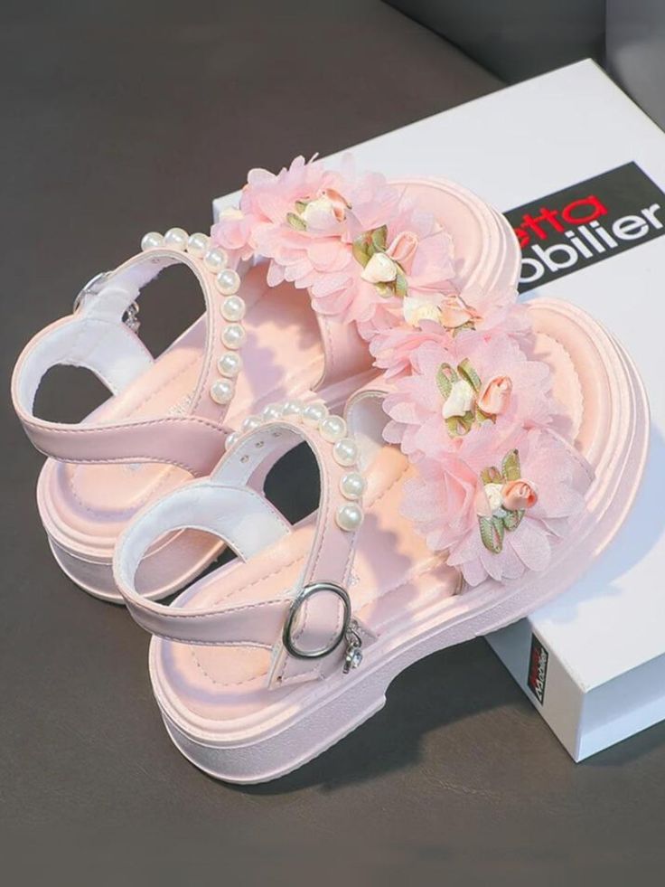 Perfect for special occasions or simply adding a bit of sparkle to her everyday outfits, these sandals are sure to become a favorite. Add a touch of elegance and charm to your little girl's wardrobe with these adorable floral and pearl sandals. These sandals feature beautiful flower embellishments that add a whimsical and sweet touch to any outfit. Available in pretty pink and classic white, these sandals can complement any outfit effortlessly. Let your little girl step out in style with these charming floral and pearl sandals. Ideal for parties, family gatherings, or just a day out, these sandals will make her feel like a true princess. Cute Sandals For Spring Parties, Pink Flower Sandals For Spring, Pink Flower Sandals For Summer, Pink Flower-shaped Sandals For Summer, Sandals With Pearls, Pearl Sandals, Flower Embellishments, Floral Sandals, All American Girl