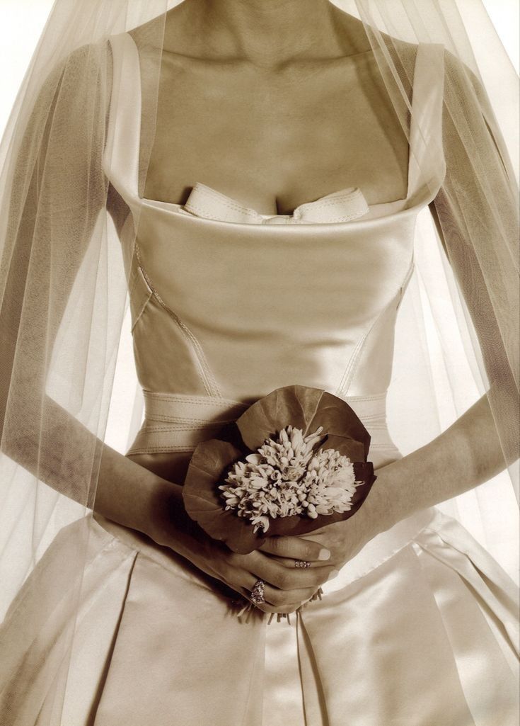 a woman in a wedding dress holding a bouquet