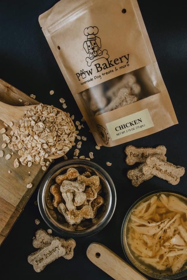 dog treats are laid out on a table next to a wooden cutting board and bag