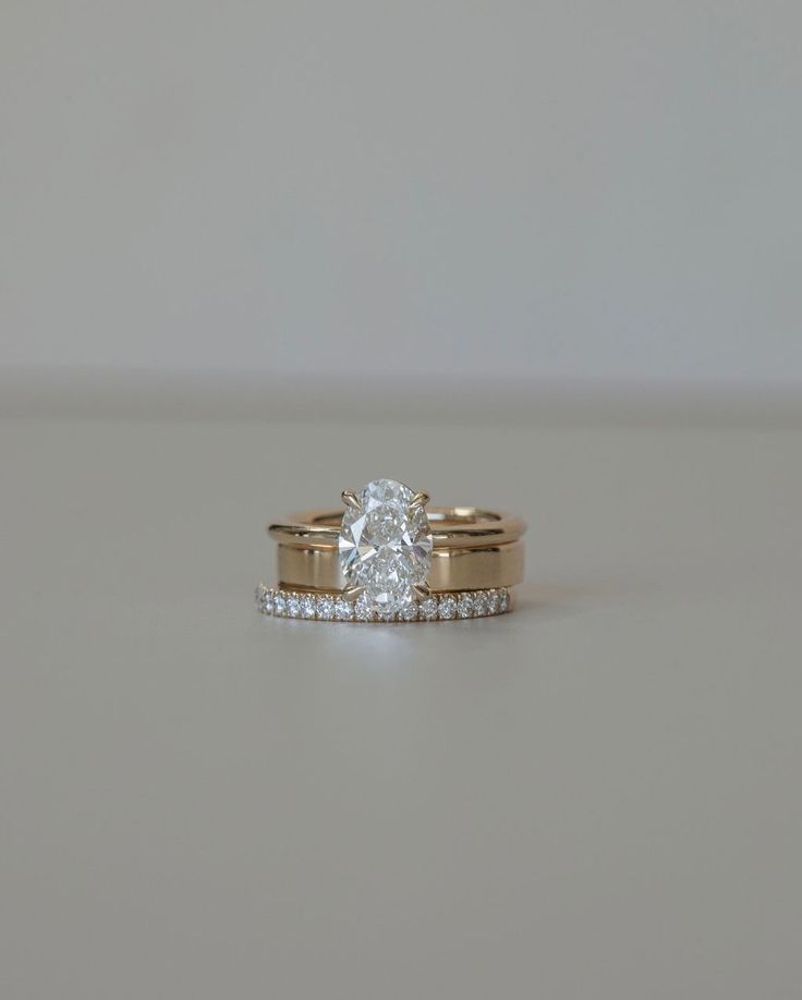 two gold wedding rings with a single diamond on each one and side stones in the middle