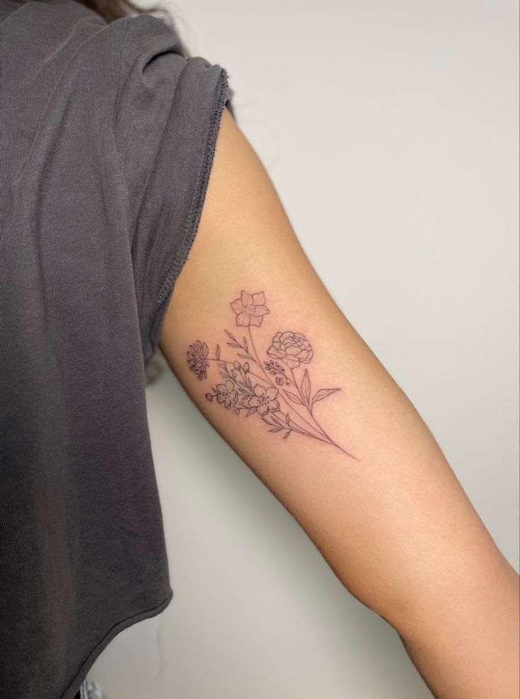 a woman's arm with a flower tattoo on the left side of her arm