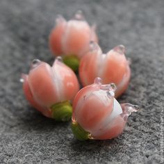 three pieces of fruit sitting on top of a gray surface next to some green leaves