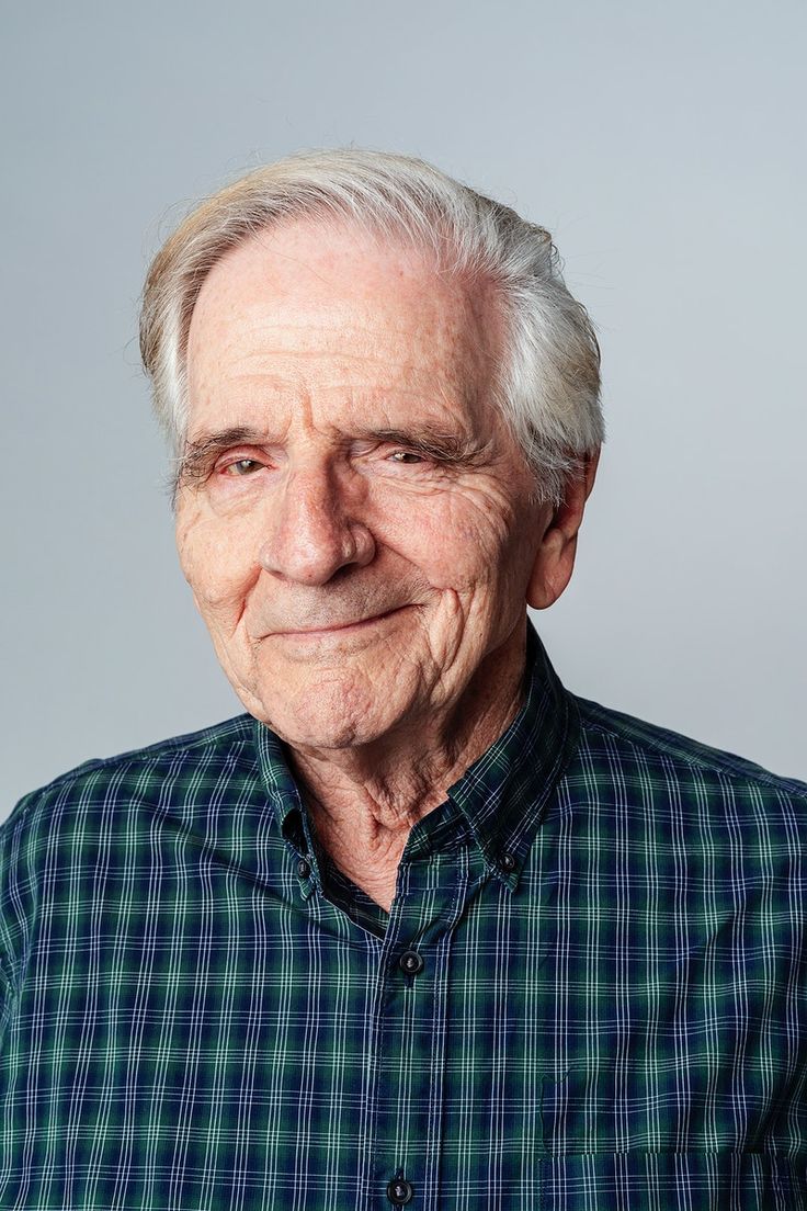 an older man with white hair wearing a green and blue checkered button up shirt