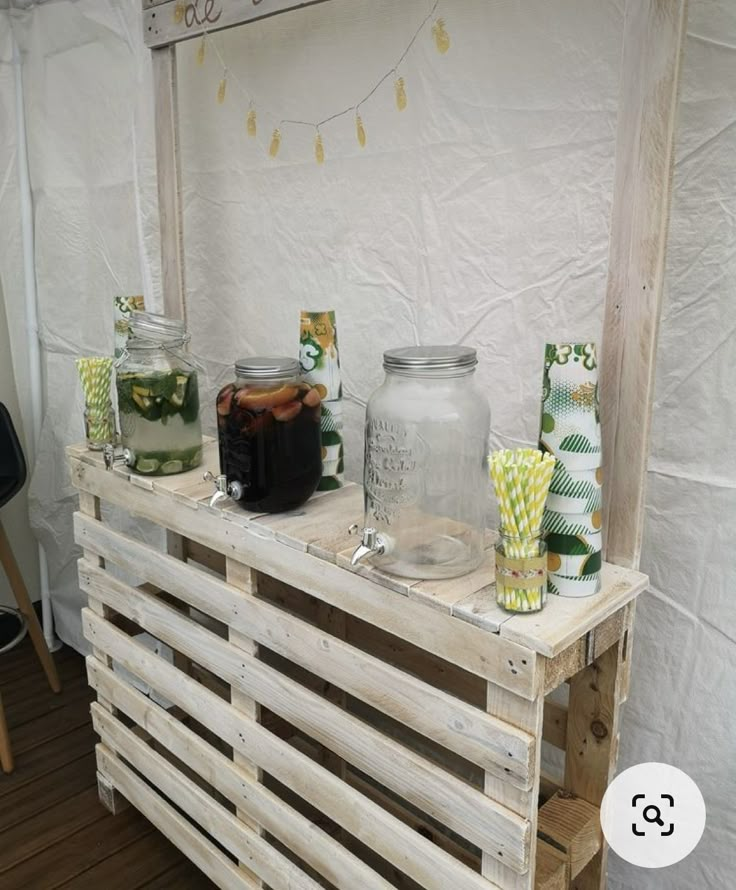 some jars are sitting on top of a pallet with green and yellow straws