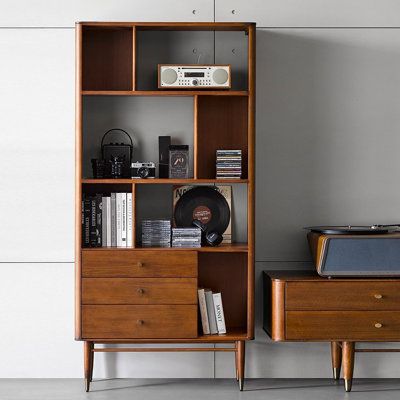 an old record player sits on top of a bookcase next to a vintage record player