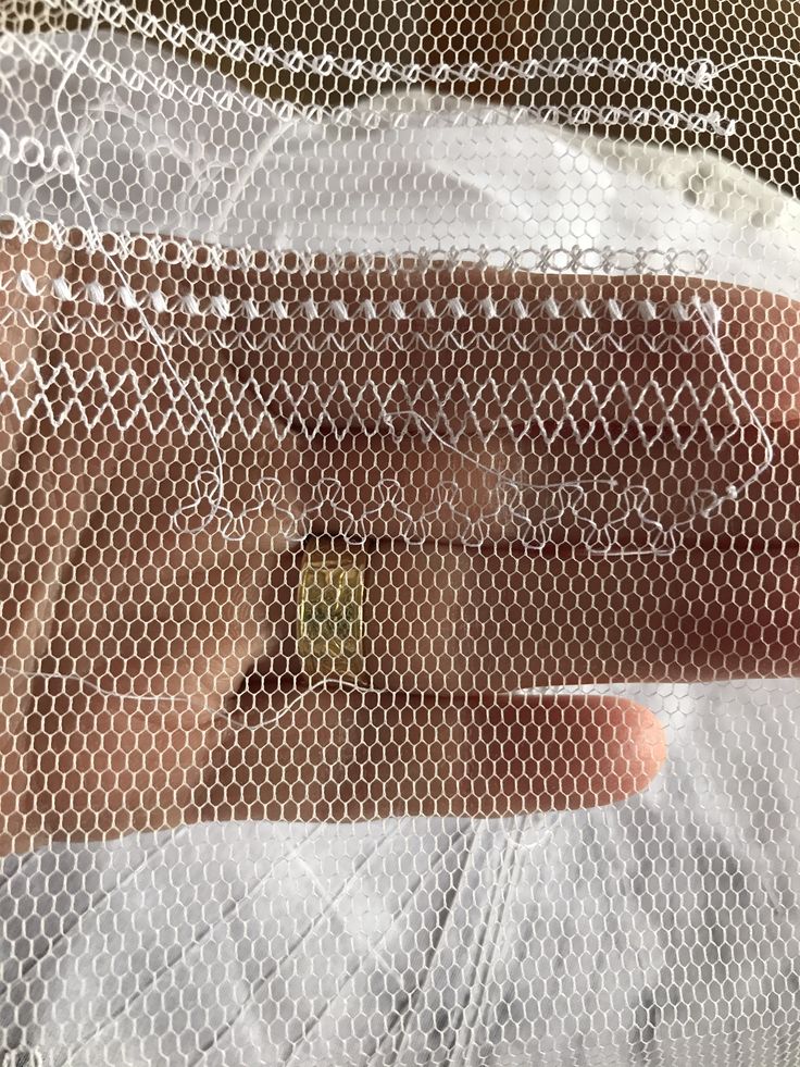 a close up of a person wearing a white dress and holding an apple in their hand