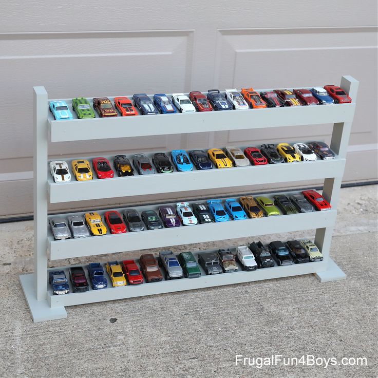 a toy car display in front of a garage door with the doors open and cars lined up on it