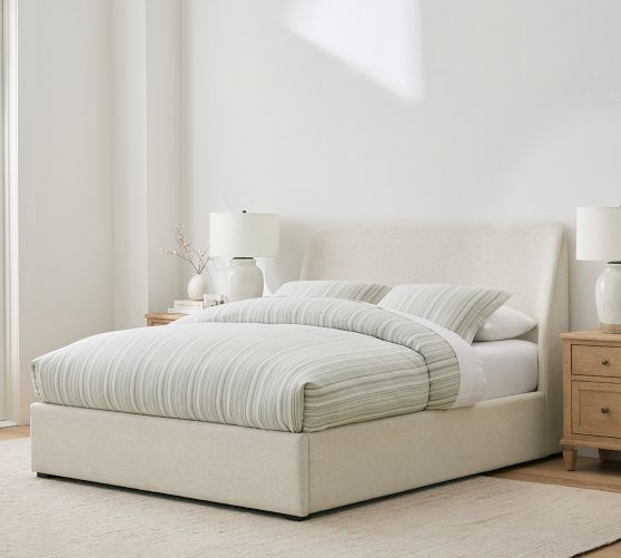 a white bed sitting in a bedroom on top of a wooden floor