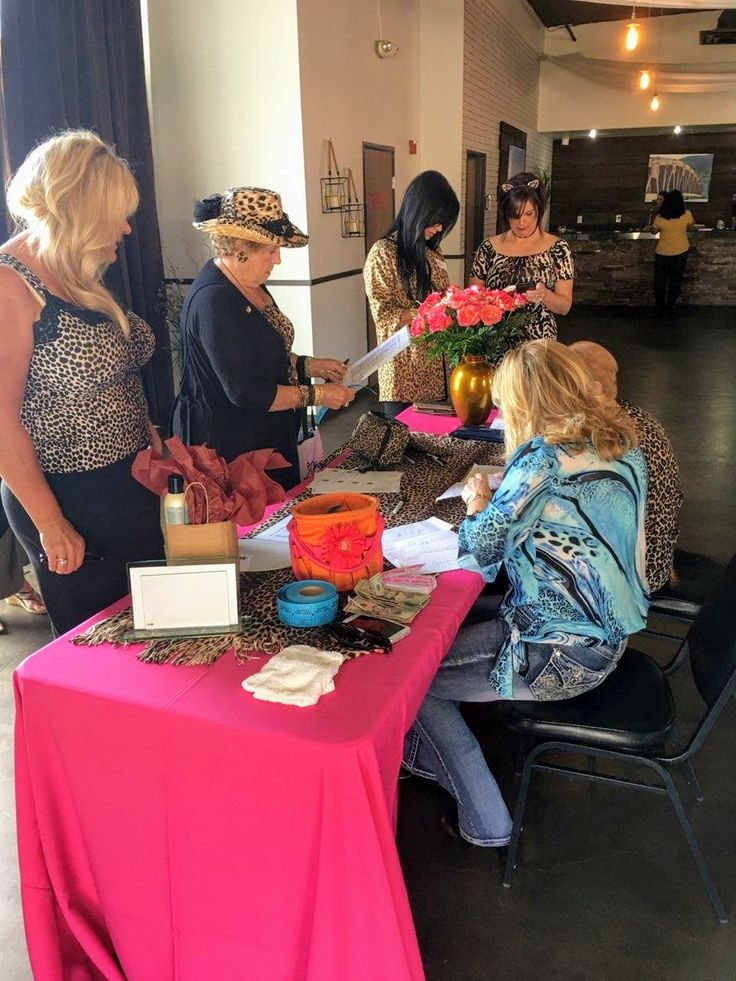 several women standing around a table with flowers on it