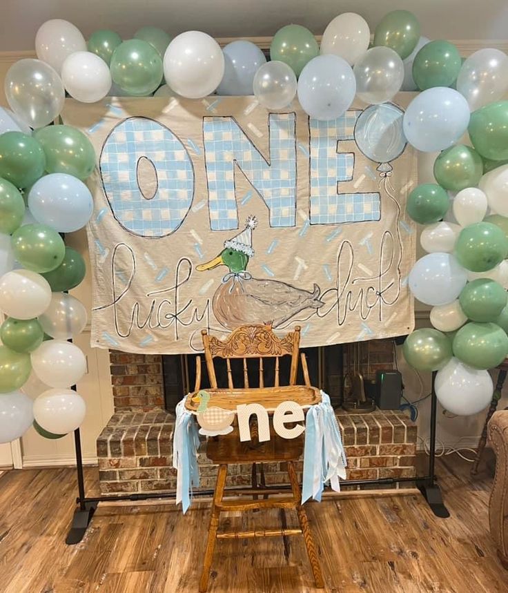 a chair sitting under a large one birthday banner