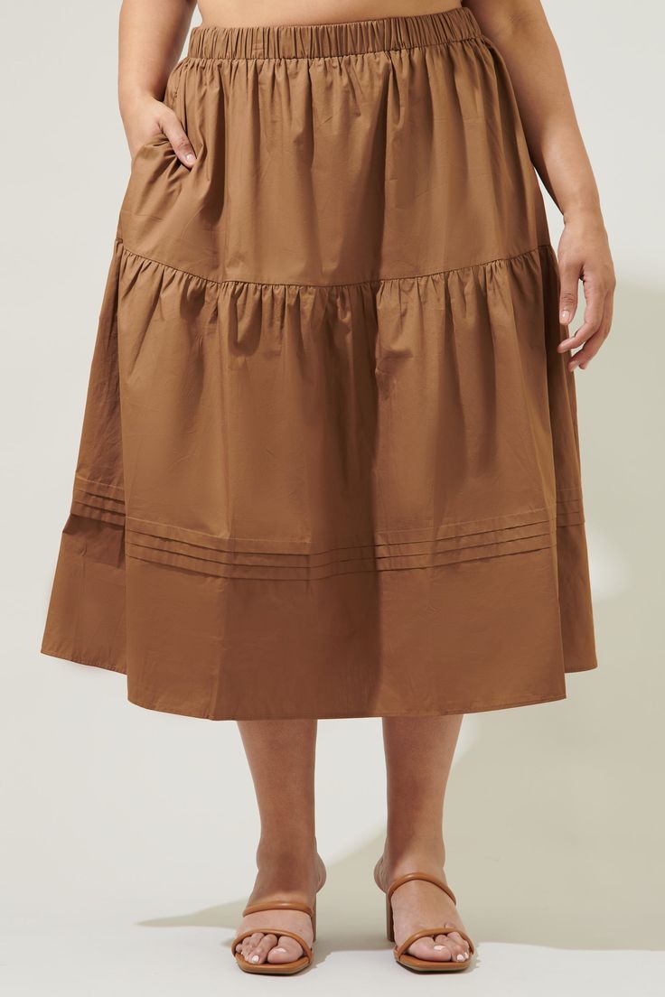 The perfect closet staple has arrived. A classic, cotton midi skirt that features an elastic waist for comfort tops an A line silhouette. Tiers break the skirt up, along with pleats that wrap around the lower tier. Pair it with a ribbed tank or an eyelet cami for the ultimate summer look.- Breathable- Pockets- A line- Pleats- Comes in 4 colorsSize + Fit - Model is 5'8" and wearing size 2X- Measurements taken from size 2X - Waist: 19 1/4"- Length: 34" Fabric self: 100%cotton Style Number STS7022X Relaxed Fit Tiered Maxi Skirt With Elastic Waistband, Knee-length Cotton Ruffled Skirt, Solid Color Full Pleated Skirt With Elastic Waistband, Pleated Full Skirt With Elastic Waistband, Full Pleated Skirt With Elastic Waistband, Pleated Voluminous Skirt For Day Out, Solid Color Tiered Skirt With Pleated Waist, Daywear Tiered Maxi Skirt With Elastic Waistband, Relaxed Fit Tiered Maxi Skirt With Lining