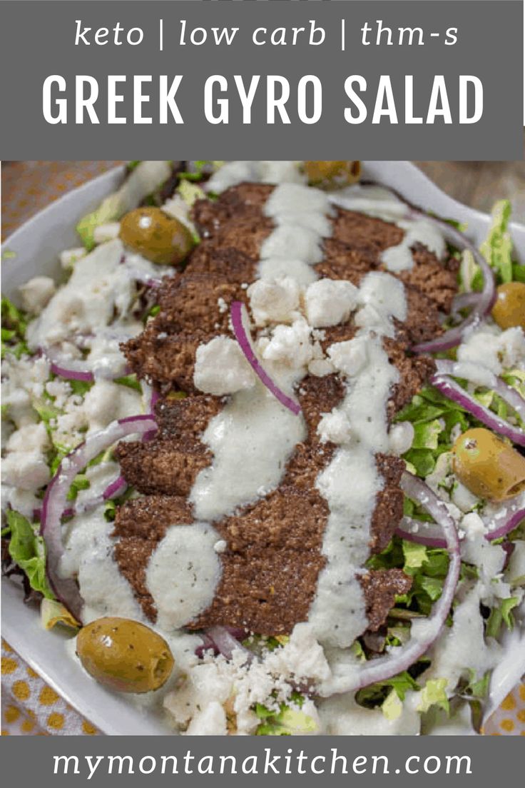 a salad with meat, cheese and onions on a white plate sitting on a table