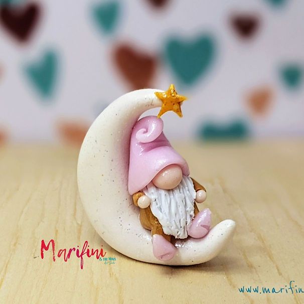 a small figurine sitting on top of a crescent with a star in it