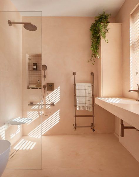 a bath room with a toilet a sink and a shower head mounted to the wall