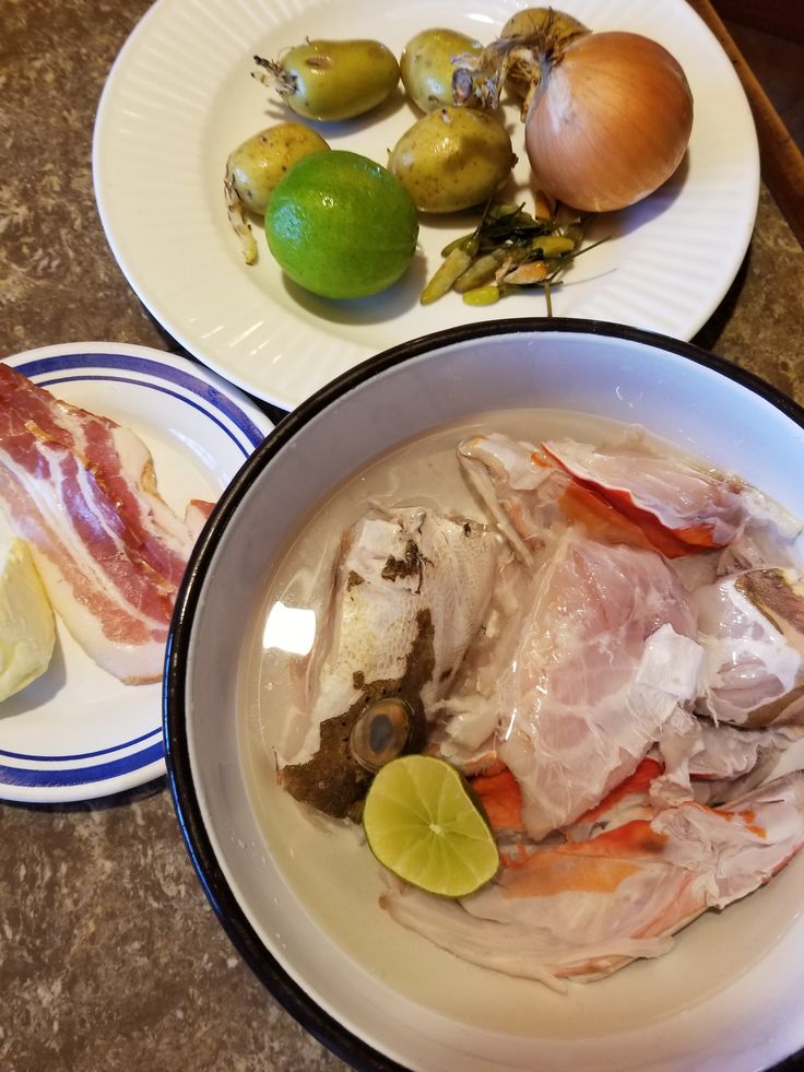 two plates with food on them sitting on a table next to some lemons and limes