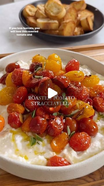 a bowl filled with mashed potatoes, tomatoes and other vegetables on top of a wooden cutting board