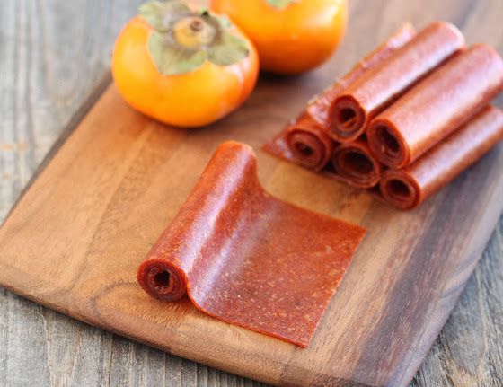 some food is laying out on a cutting board next to an orange and two peppers