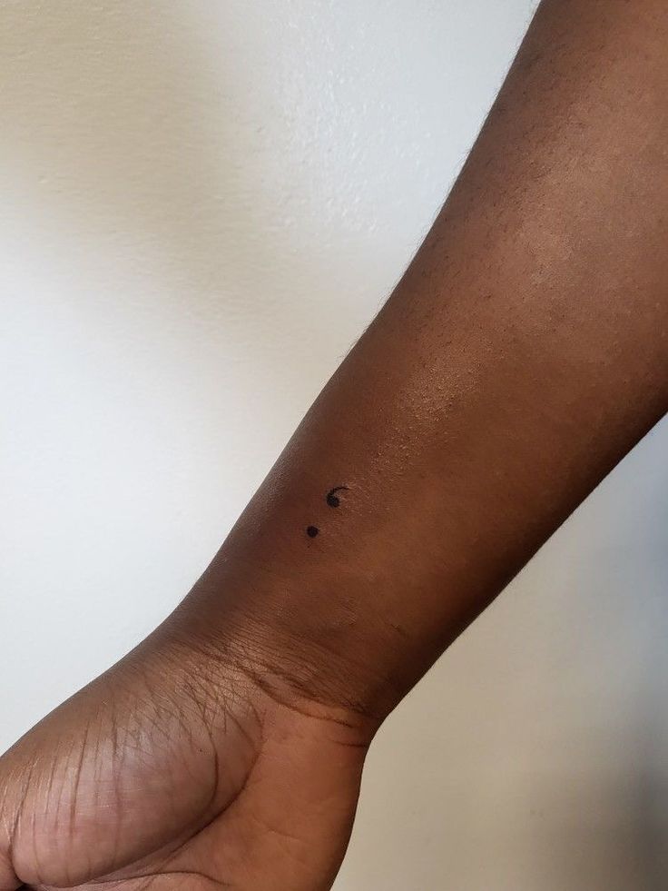 a person's arm with a small black dot on it