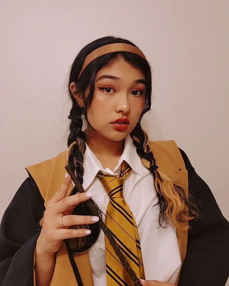 a woman with braids wearing a yellow tie