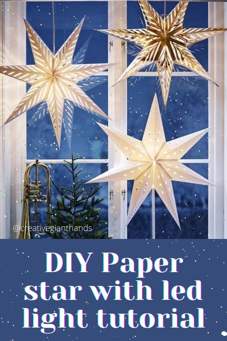 some paper stars hanging from a window with the words diy paper star with led light