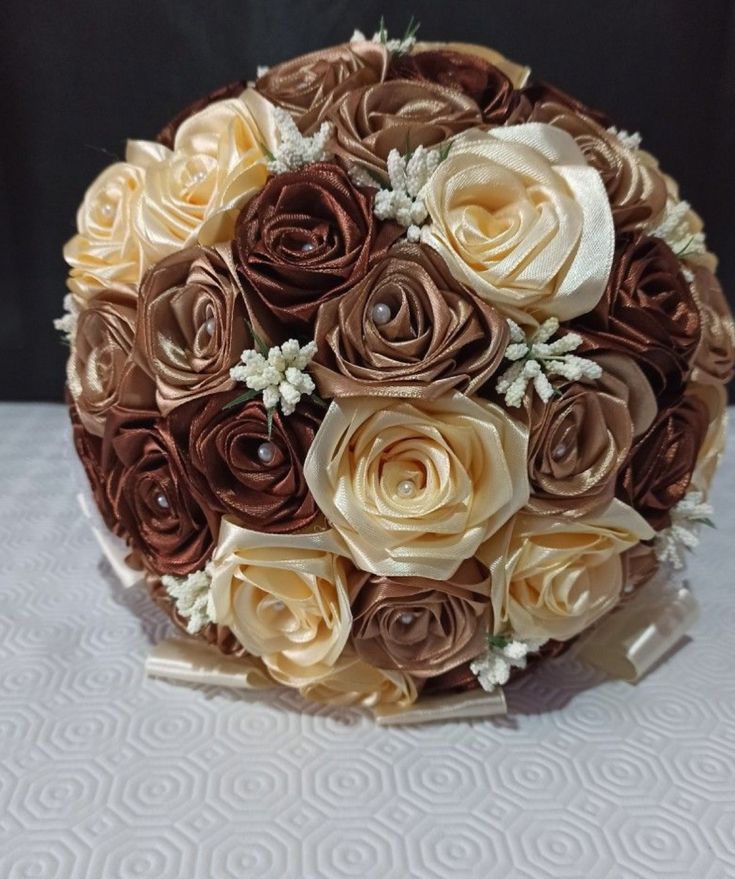 a bridal bouquet made up of brown and white flowers on top of a table