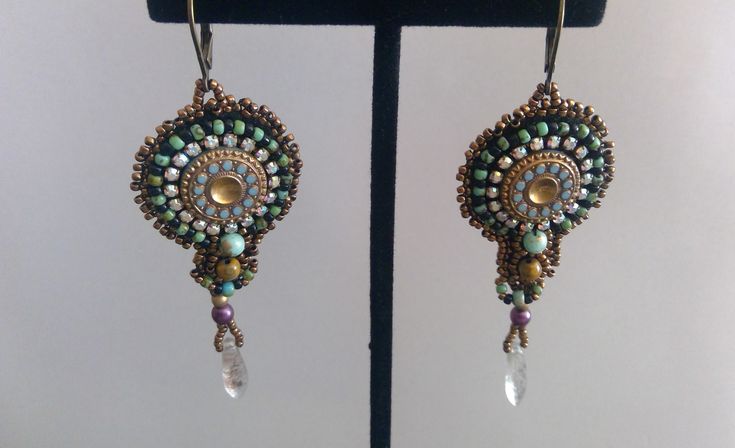 This Sherry Serafini inspired dangle earring is right for any occasion. The vintage center bead is surrounded with crystals, seed beads, a turquoise bead and a tiger's eye bead. The lever-back ear wires make for a secure wearing option. Stunning. Bohemian Jeweled Beaded Drop Earrings, Bohemian Jeweled Dangle Beaded Earrings, Bohemian Jeweled Beaded Dangle Earrings, Bohemian Style Jeweled Beaded Dangle Earrings, Bohemian Jeweled Beaded Earrings For Gifts, Sherry Serafini, Turquoise Dangle Earrings, Turquoise Earrings Dangle, Tiger Eye Beads