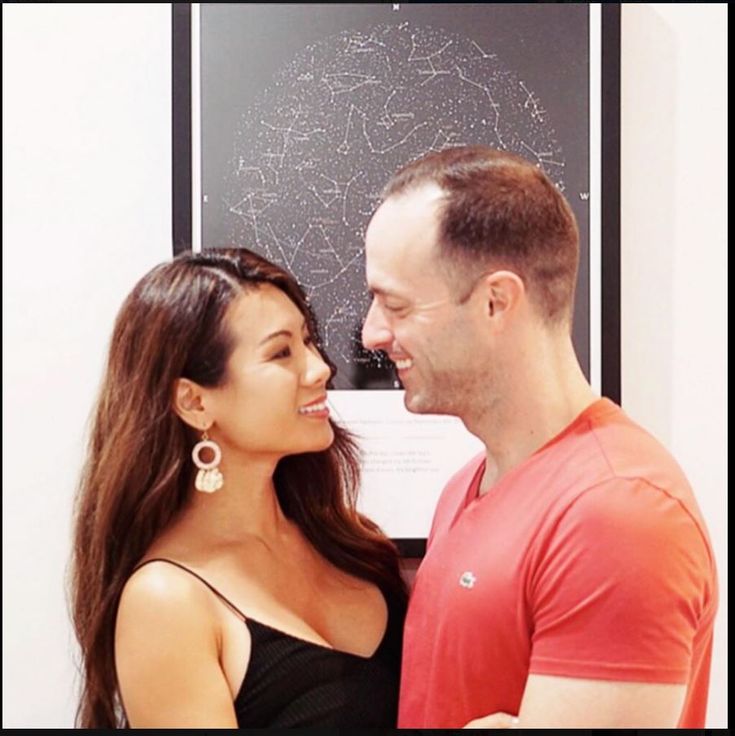 a man and woman standing next to each other in front of a blackboard with stars on it