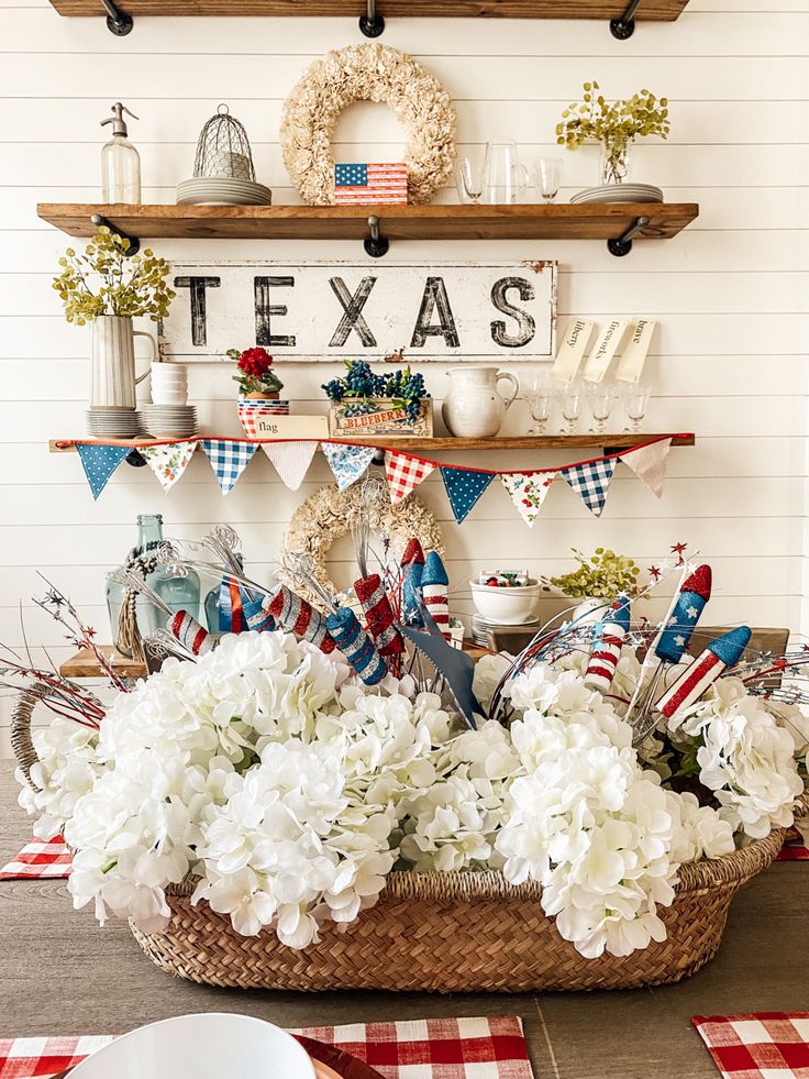 a basket filled with white flowers sitting on top of a table next to plates and utensils