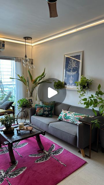 a living room filled with lots of furniture and plants on top of a pink rug