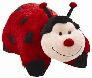 a ladybug stuffed animal laying on top of another stuffed animal with its eyes closed