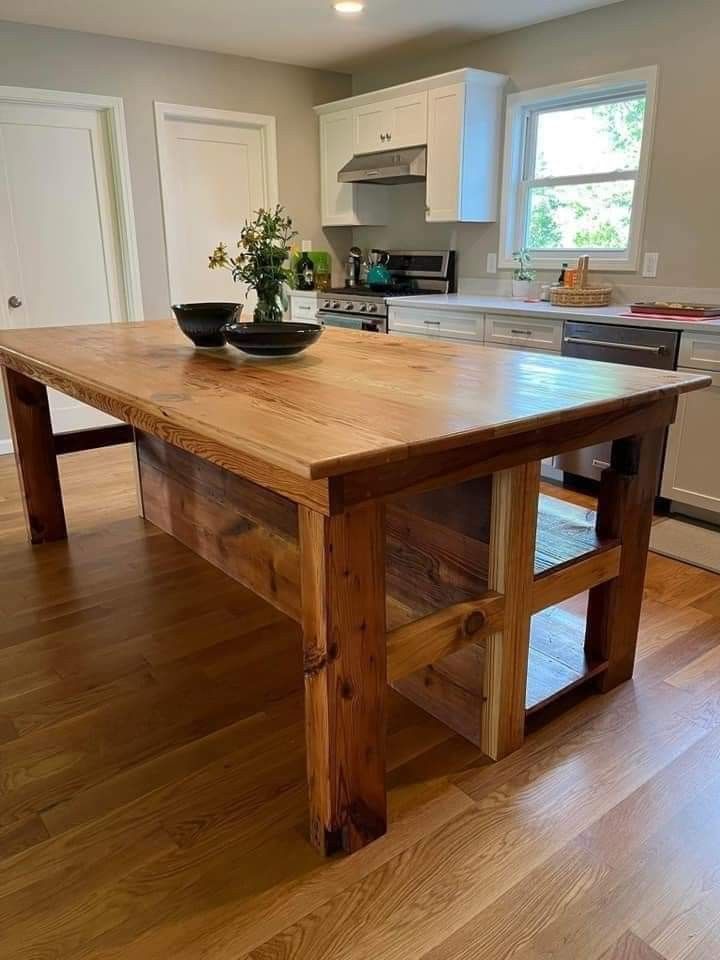 a wooden table sitting in the middle of a kitchen