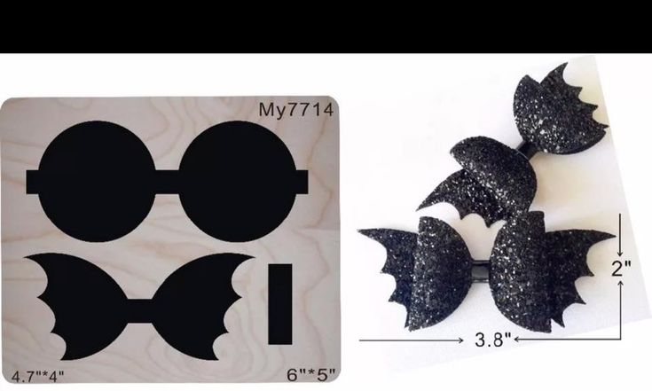 some black and white paper cut outs next to a ruler with the shape of bats on it