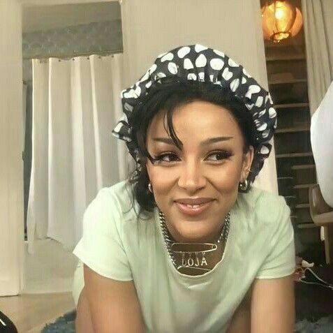 a woman is laying on the floor wearing a polka dot headband and smiling at the camera